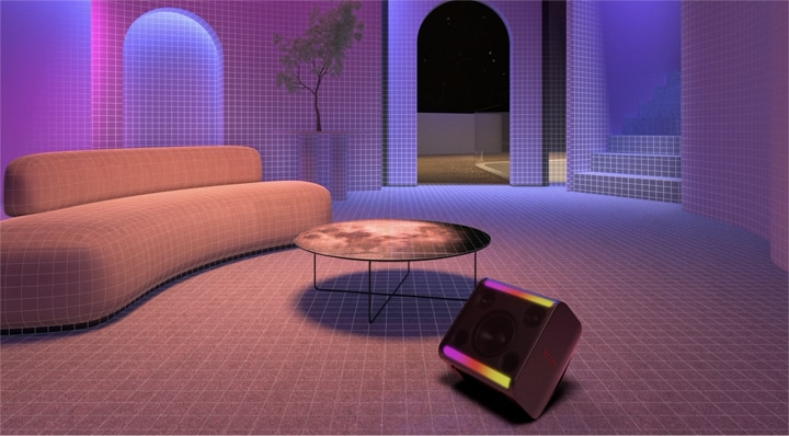 Em uma sala equipada com um sofá longo, uma mesa redonda e uma planta, o xboom Stage 301 é colocado na frente com sua luz acesa.
