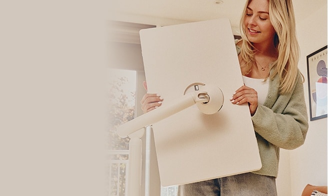 A woman detaching a StanbyME 2 smart screen from its stand.