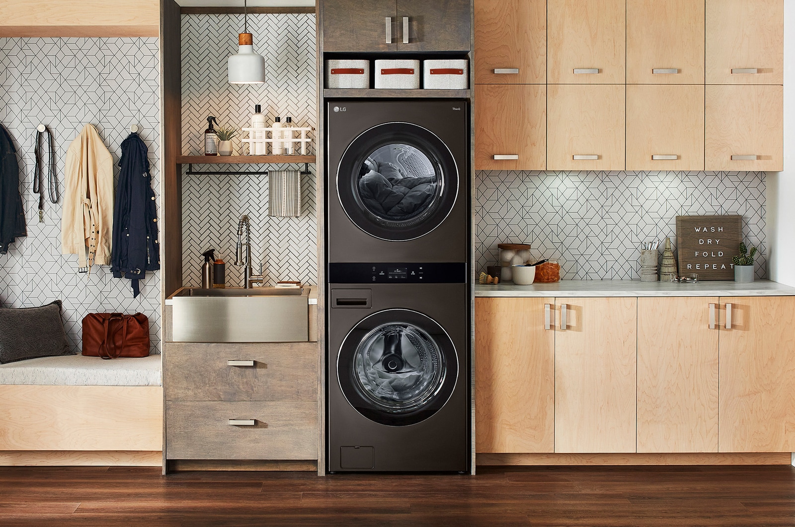 The LG WashTower WKEX300HBA in Black Steel, showcasing its space-saving single-unit design seamlessly integrated into a stylish, modern laundry room.