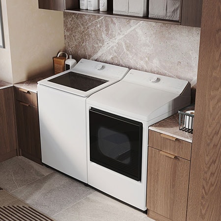 The LG Top Load Washer and Dryer set (WT8205CW) in White, showcasing its premium, side-by-side design seamlessly integrated into a luxurious laundry room with marble and wood finishes.