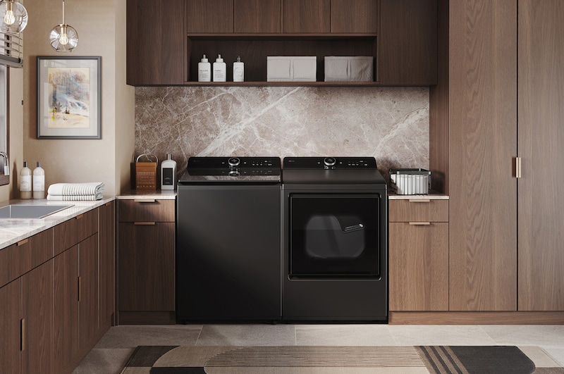 The LG Top Load Washer and Dryer set (DLEX8600BE) in Black Steel, showcasing the flat-top design and premium finish integrated perfectly beneath the upper cabinetry.