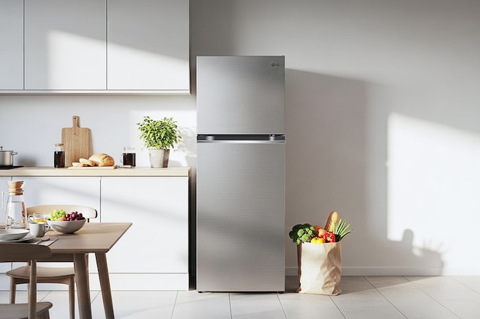 The stainless steel finish LG 24-inch 11 cu.ft. Top Freezer Refrigerator LT11C2000V, shown placed in a bright, modern kitchen setting.