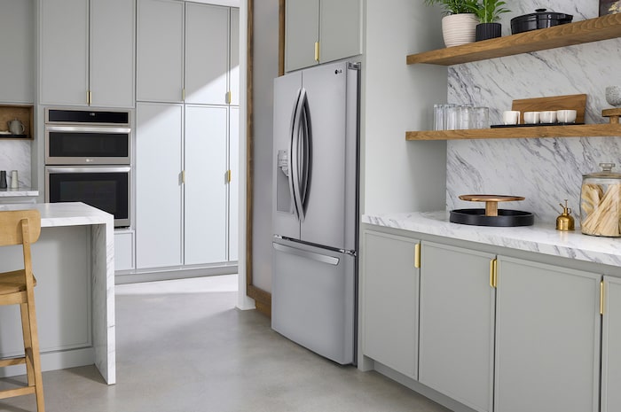 The PrintProof™ Stainless Steel LG 36-inch 28 cu.ft. French Door Refrigerator LRFS28XBS with ice & water dispenser, shown in a bright modern kitchen.