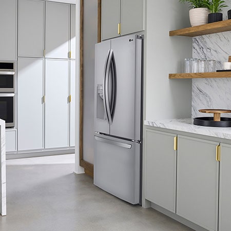 The PrintProof™ Stainless Steel LG 36-inch 28 cu.ft. French Door Refrigerator LRFS28XBS with ice & water dispenser, shown in a bright modern kitchen.