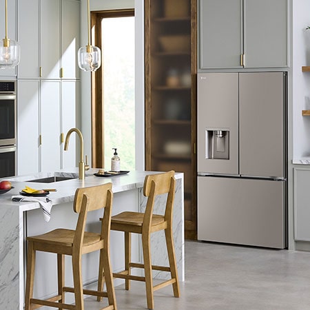 The stainless steel finish LG 36-inch 26 cu.ft. French Door Refrigerator LRYXC2606S, shown installed in a modern kitchen with light wood cabinets.
