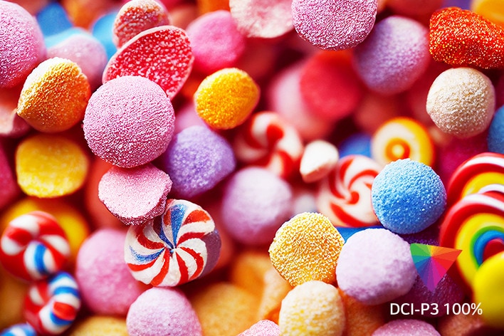 Close-up of vibrant, colourful candies with various textures and shapes, featuring the DCI-P3 100% logo in the corner.