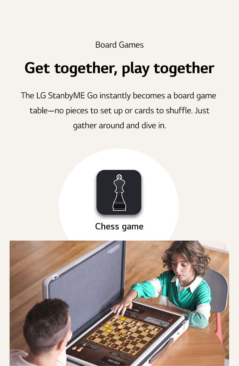 Father and son plays chess game through the LG StanbyME Go. In the middle of the image, Chess game icon is shown.