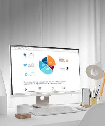 On the table, there is a smart monitor, displaying a home office document being worked on. To the left of the monitor, there is a cup with a handle, and to the right, there is a mobile phone, a pencil holder, and a stand.