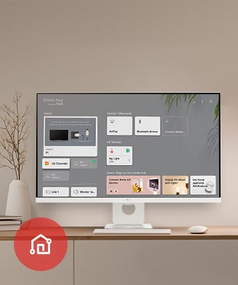 On the table, the monitor displays the Home dashboard screen, with the LG ThinQ App icon visible in the bottom left corner.