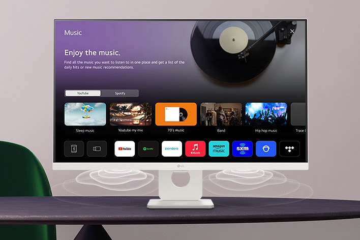 The smart monitor screen placed on the table displays the MUSIC APP screen.