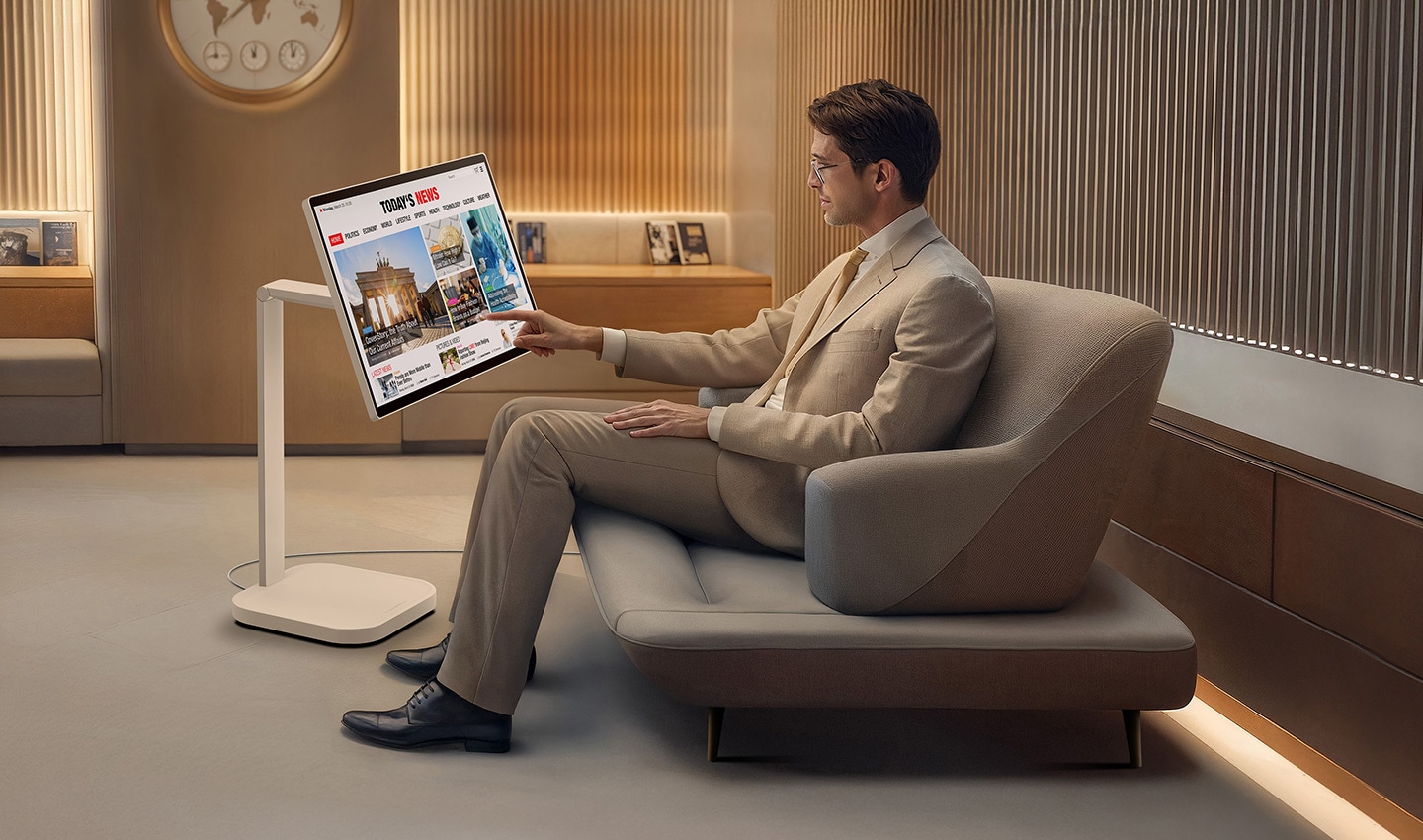 A man in the VIP lounge is reading the news on a LG Smart Monitor Swing. A man in the VIP lounge is reading the news on a LG Smart Monitor Swing.