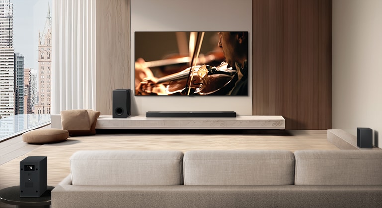 LG Soundbar, LG TV, a subwoofer and rear speakers are in a modern city apartment. The background gets dimmed, and the grid overlay appears over the image from LG TV, like a scan of the space. A dotted line extends from one of the rear speaker, to show the two rear speakers are in a linear fashion. White soundwaves made of droplets are coming out from the frontal perspective of the rear speakers.