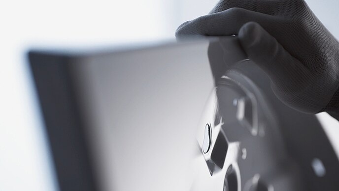 A hand of craftsman is tounching the enamel coated body of LG SIGNATURE Washing Machine.