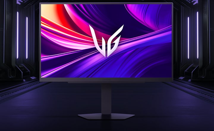 Vue de face du moniteur gaming LG UltraGear™ 27G810A sur son socle hexagonal, installé dans un couloir futuriste éclairé au néon ; l’écran affiche des tourbillons violets et rouges éclatants avec le logo UltraGear au centre.