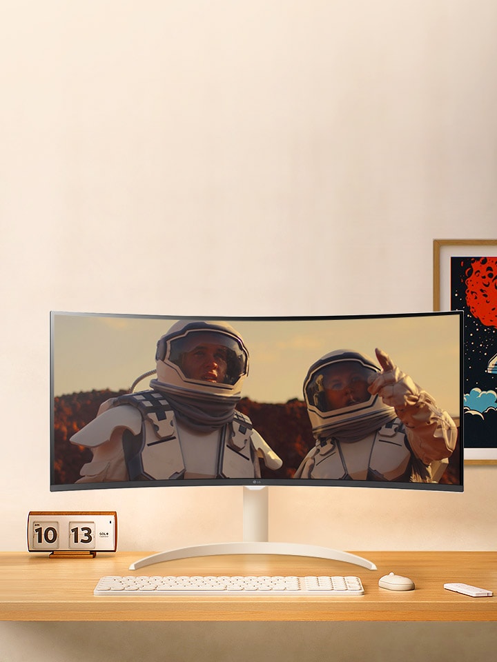 There is a monitor on the desk, and a movie is playing on the monitor screen.