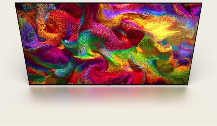 Multi-colored sand explodes in all directions, forming a swirling pattern, then appears as the display of an LG TV.