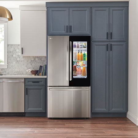 Le réfrigérateur à portes françaises LG LRFGC2706S de 36 po et 27 pi³ en acier inoxydable PrintProof™ avec porte InstaView™ Porte dans la porte®, présenté dans une cuisine moderne.
