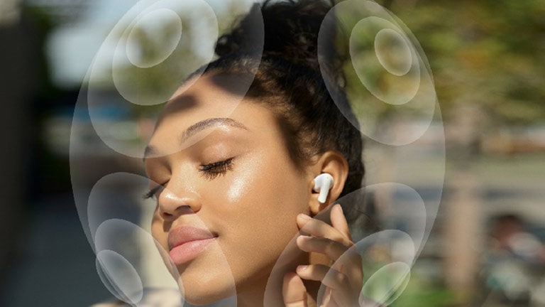 Image de femme qui touche le LG TONE Free sur son oreille. Présentation du virtualiseur