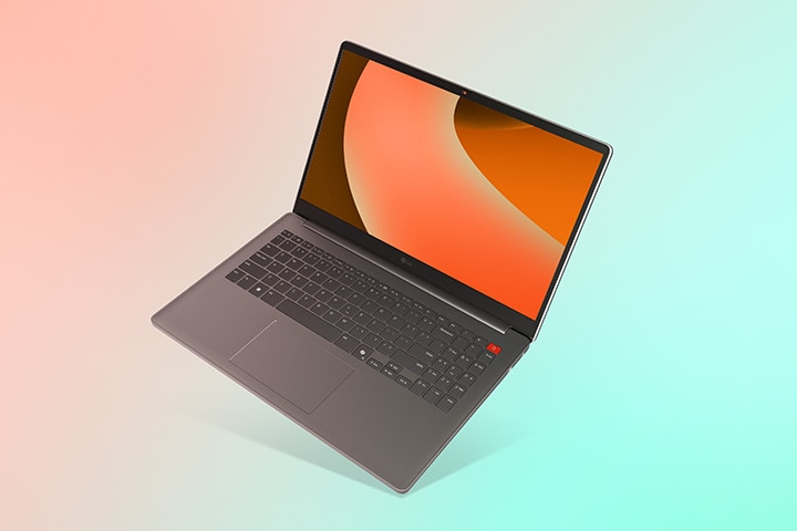 This image shows a gray laptop with the screen open. The background features a soft gradient, blending pink on the left and green on the right.