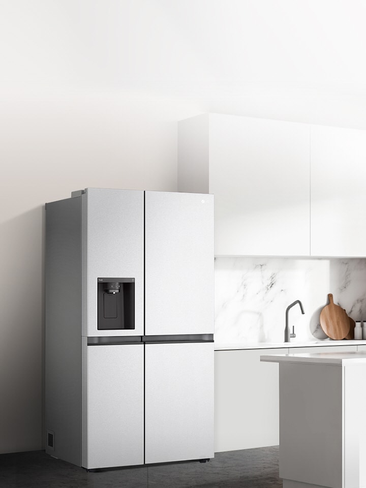 A side view of a kitchen with a silver side by side refrigerator installed.