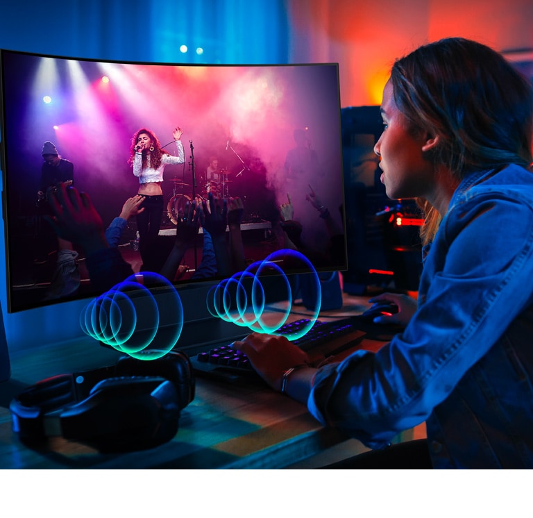 Image d’une personne regardant un concert sur le téléviseur OLED Flex de LG. Des bulles de parole illustrent le son émis à l’avant du téléviseur.