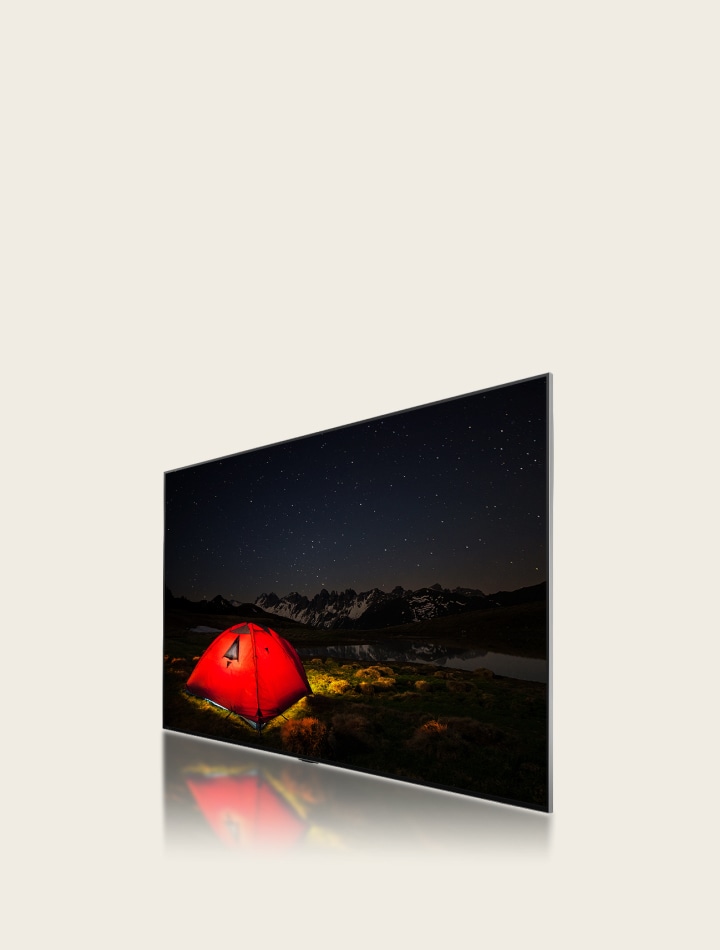 Vue latérale d’un LG TV montrant une image terne et floue d’une tente la nuit. Une couche du téléviseur se déplace vers l’arrière en affichant de grandes zones d’obscurcissement, puis des zones d’obscurcissement plus petites et bleues se déplacent pour les remplacer. Le calque avance pour se reconnecter au LG TV, puis l’image de la tente devient plus claire et plus lumineuse.