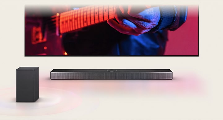 Un LG TV montrant un homme jouant de la guitare et une LG Soundbar juste en dessous, avec un autre haut-parleur à l’avant.