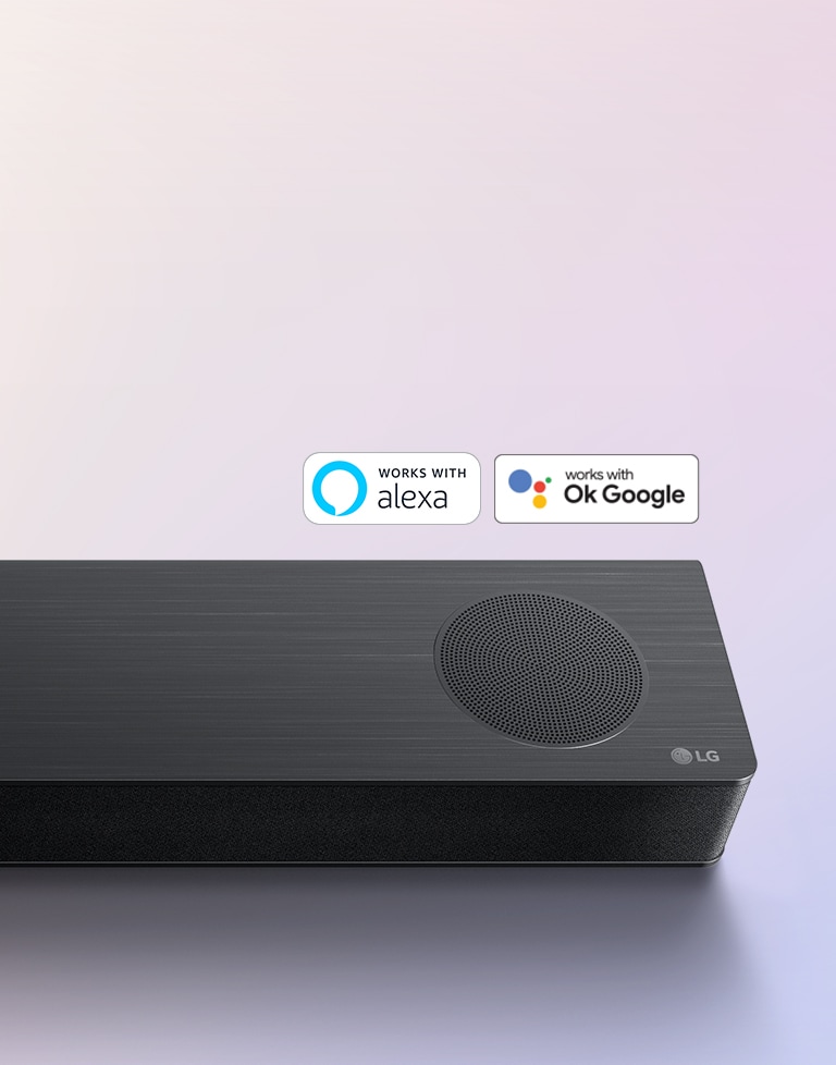 Die LG Soundbar steht auf dem Boden. Unten rechts auf der Soundbar ist das LG-Logo zu sehen. Die Logos von Alexa und OK GOOGLE befinden sich oberhalb von der Soundbar.