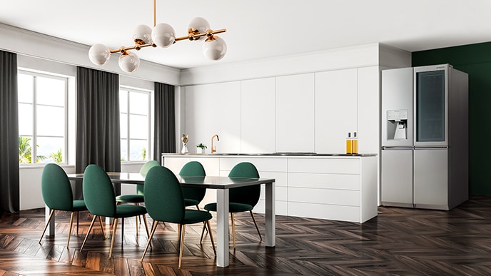 LG SIGNATURE Refrigerator befindet sich auf der rechten Seite des Hauses und der Küchentisch mit mehreren grünen Stühlen auf der linken Seite.