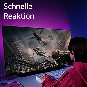 Ein Mädchen spielt ein Computerspiel auf einem Großbildschirm, auf dem ein Soldat zu sehen ist, der sich aus einem Hubschrauber herunterlässt.