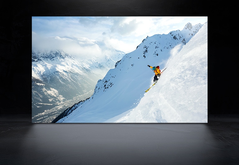 Ein TV-Bildschirm, der einen Mann beim Skifahren in den verschneiten Bergen sowohl auf dem LG OLED als auch auf dem LG OLED evo zeigt, um den Unterschied in der Helligkeit und Schärfe des Bildes zu verdeutlichen. (Video abspielen)