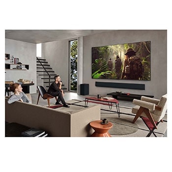 On an LG OLED TV screen is the webOS 25 home page filled with apps and entertainment content. By the TV is the LG AI Magic Remote, the AI button is highlighted as if activated by the user's voice. A speech bubble is beside it, switching to my account. The short text explains how users can now synchronize their voice to their personal profile for easier navigation and personalized recommendations.