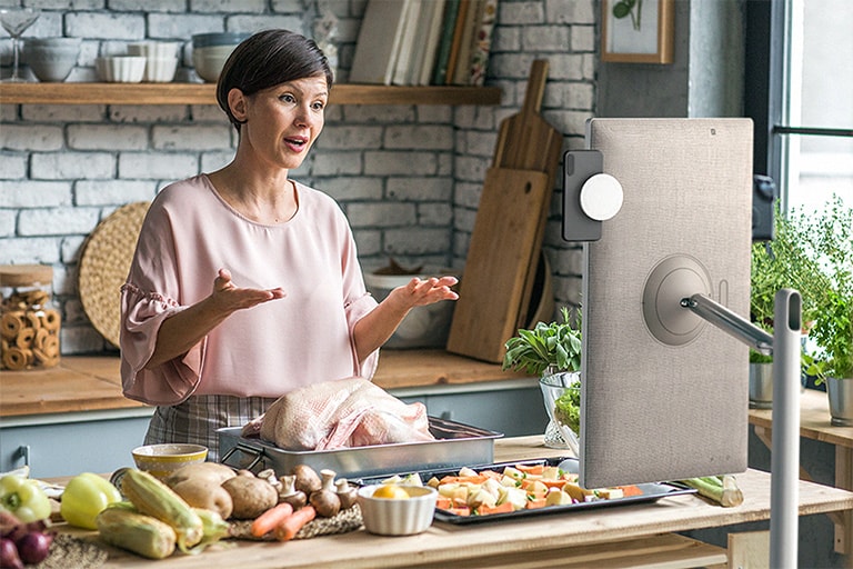 Der Fernseher steht vor einer Badewanne im Badezimmer und der Bildschirm zeigt eine tanzende Frau im Regen. Ein weiteres Bild zeigt die Rückseite eines Fernsehers im Wohnzimmer und eine Nahaufnahme des NFC-Symbols auf der Rückseite des Fernsehers. Es gibt ein separates NFC-Logo.