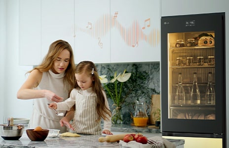 Image d’une mère et son enfant cuisinant en face d’un réfrigérateur avec de la musique.