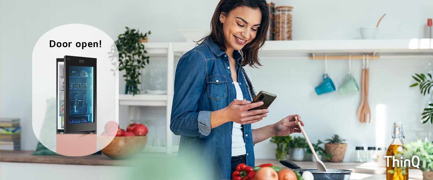 Une image d’une femme qui cuisine tout en regardant son téléphone et un réfrigérateur avec une porte ouverte.