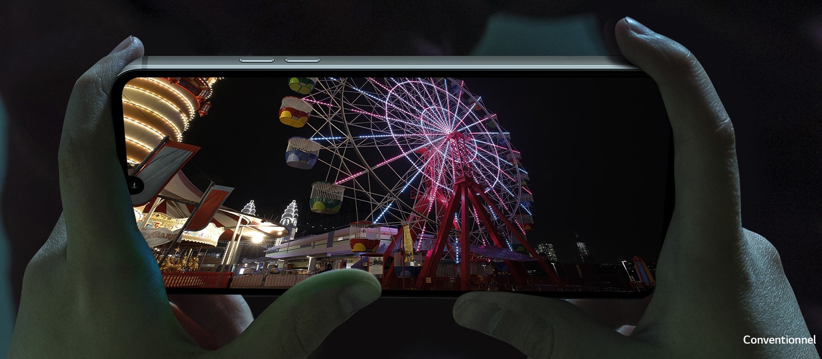 Vidéo de nuit d’un parc d’attractions lue sur l’écran d’un smartphone.