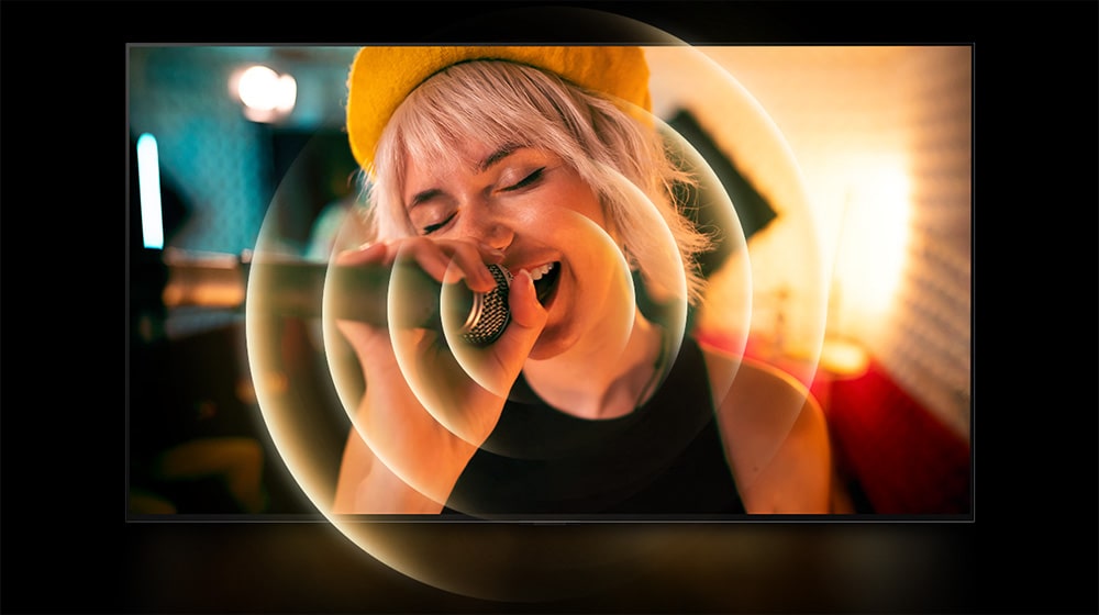 Une femme chantant avec un microphone à la main et un cercle orange jaillit autour de sa bouche pour montrer l’environnement sonore.