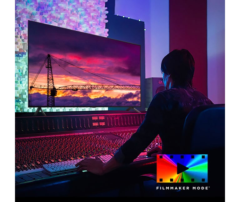 Un homme dans un studio de montage sombre regardant un LG TV affichant le coucher du soleil. En bas à droite de l’image se trouve le logo du FILMMAKER Mode.