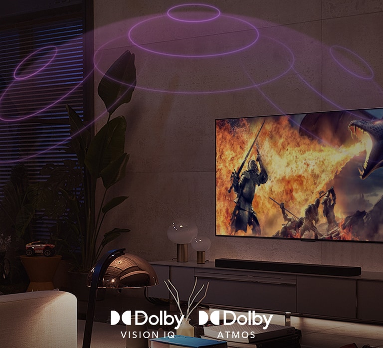 Le logo de Dolby Vision IQ et d’Atmos sont alignés horizontalement. Sous les logos, un père et son fils sont assis sur un canapé et regarde un téléviseur affichant une fille tenant un minérai au milieu d’un arrière-plan noir et orange.