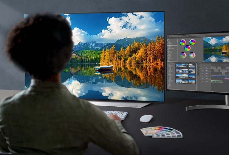 Un ingénieur dans un atelier manipule un contrôleur pour régler une image affichée sur un moniteur.