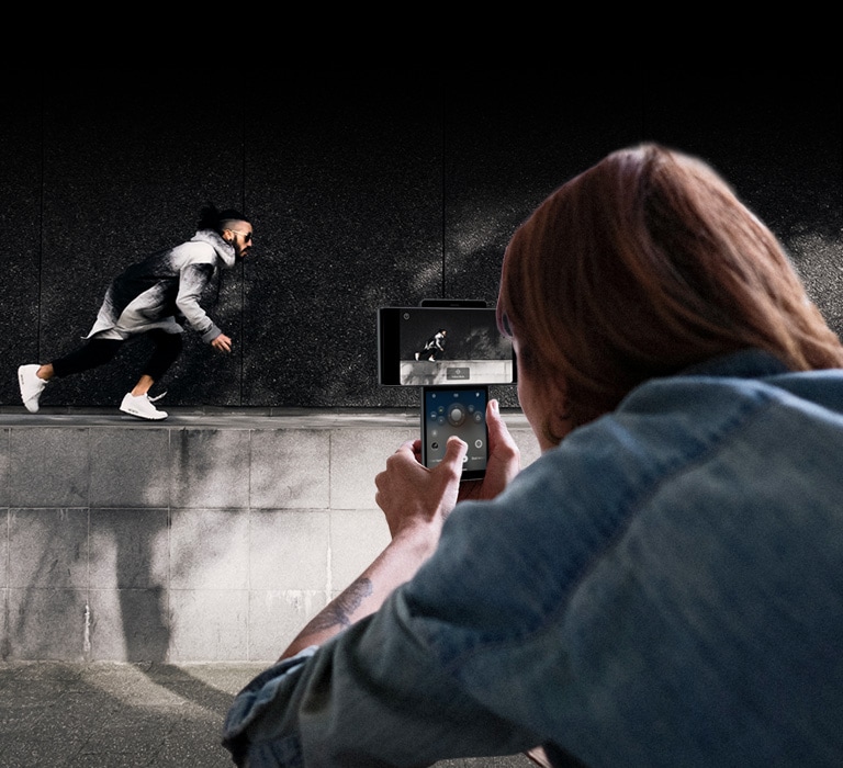 Femme filmant un homme en train de courir.