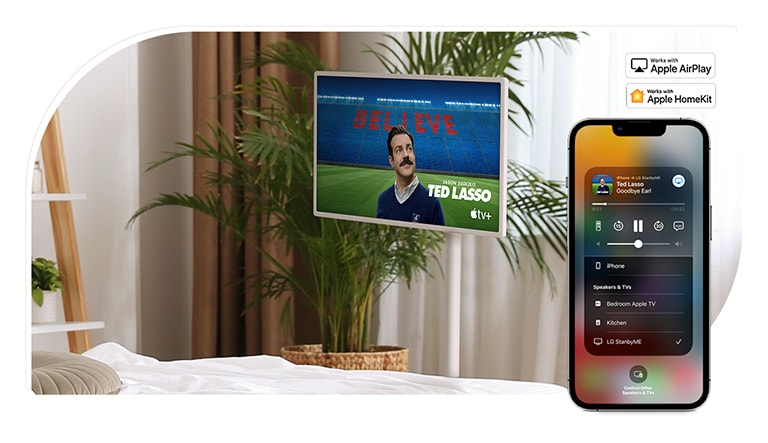 Se coloca un televisor en un dormitorio acogedor y la pantalla muestra el programa de televisión: TED LASSO. Hay un dispositivo móvil en la misma imagen que muestra la interfaz de usuario de AirPlay en su pantalla. Hay el logotipo de Apple AirPlay y el logotipo de Apple HomeKit ubicados en la esquina superior derecha de la imagen.