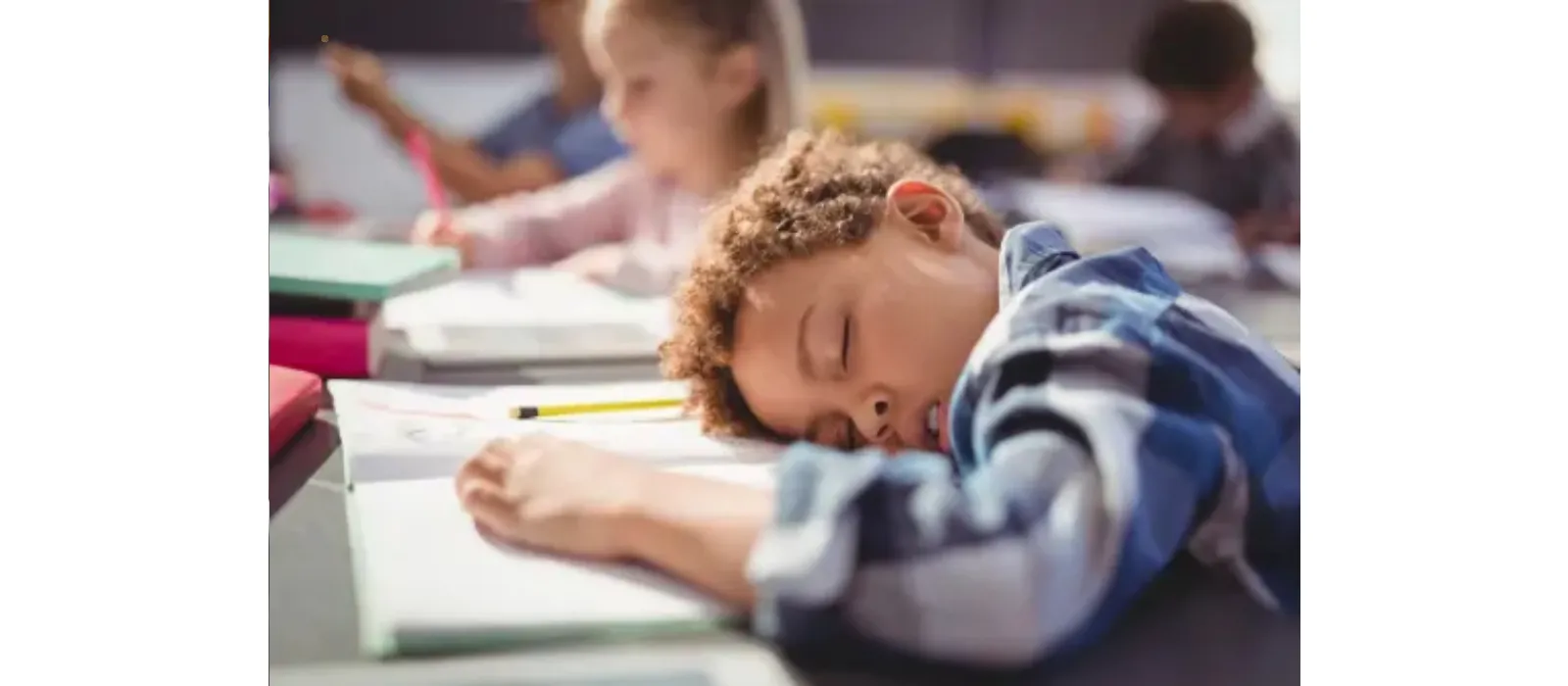 Niño en un escritorio de clases durmiendo