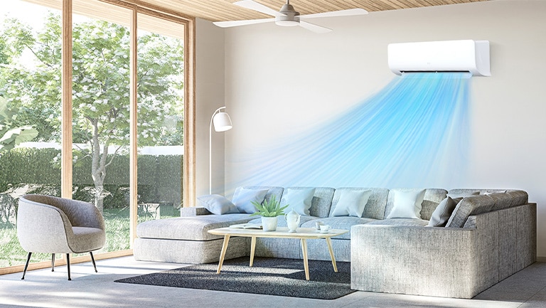 The air conditioner is operating on the wall in the living room with big window on the left and cool air from the air conditioner is spreading out.