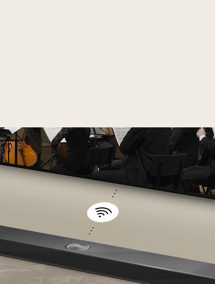 Detail LG Soundbaru pod LG TV. Mezi LG Soundbarem a LG TV je symbol konektivity, který znázorňuje bezdrátový provoz zařízení WOWCAST.