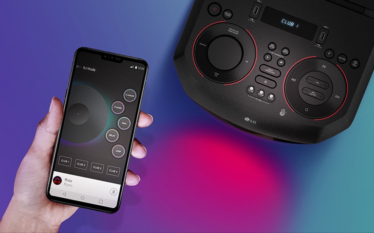 Ruka držící chytrý telefon vedle horní části reproduktoru LG XBOOM.
