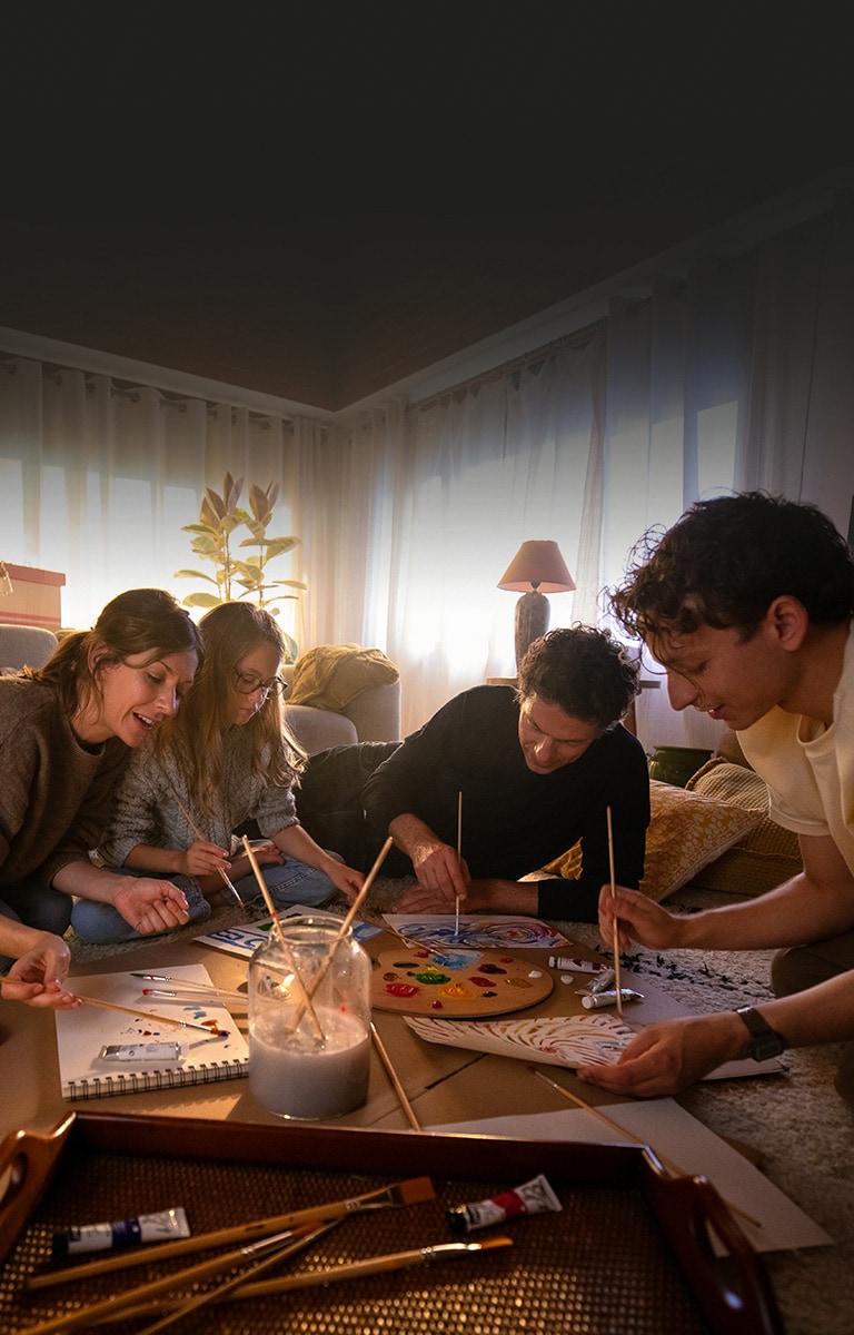 Členové rodiny jsou spolu na útulném koberci v obývacím pokoji a kreslí si obrázky v příjemném teple domova.