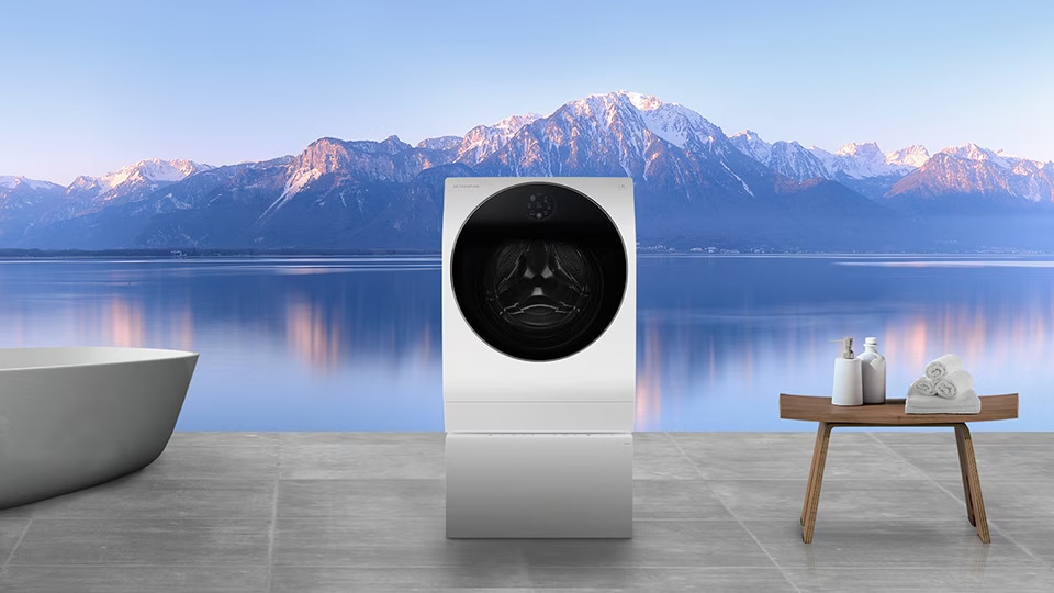 LG SIGNATURE Pračka a vana jsou položeny v prádelně s výhledem na hory a řeku najednou za oknem.