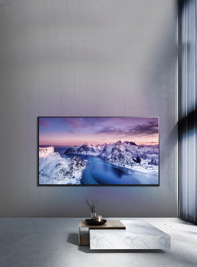 Ultra HD televizor namontovaný na stěně za stolem s dekoracemi ve stylu zen.