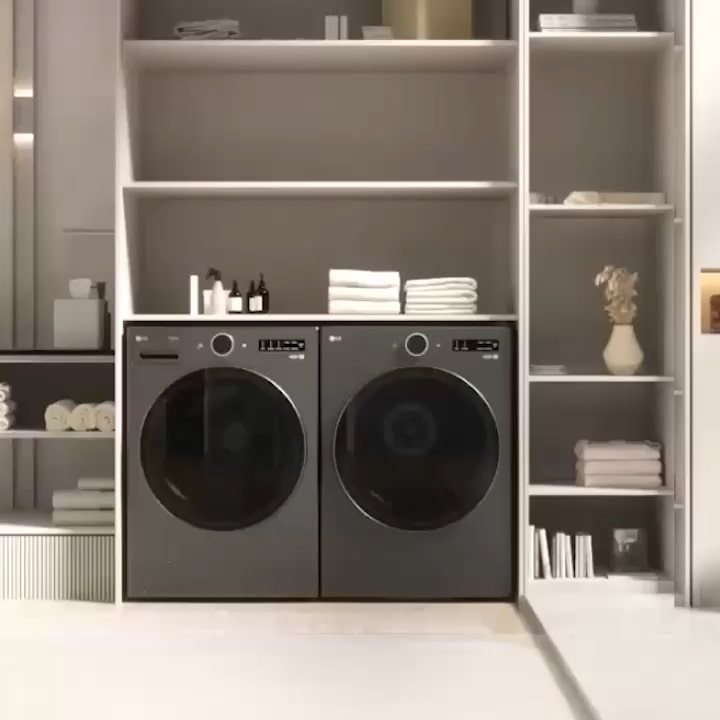 LG WashTower installed inside a cabinet, with a leaning laundry rack on the left beside a bathroom mirror, sink and towels, and plants with folded towels on the right.
